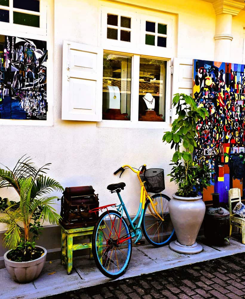 Shows a shop with a brightly coloured bike outside and a range of objects 
