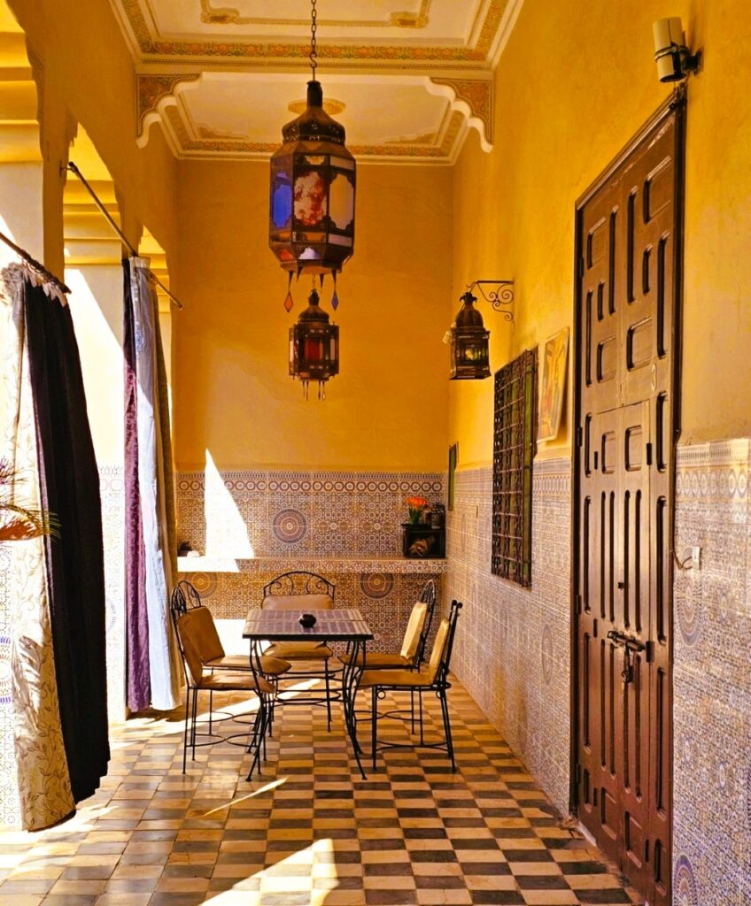 An outdoor tiled eating space, with a Moroccan lamp at  Riad Elaissi in Taroudant 