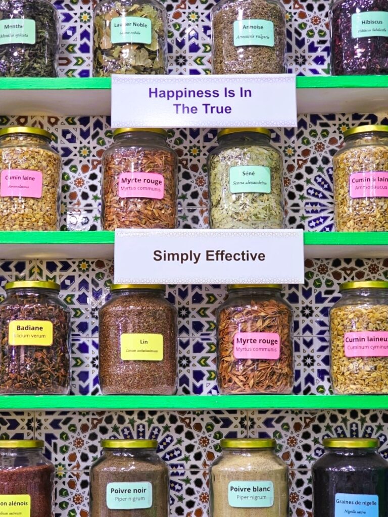 several jars full of herbs on a shelf with the sign saying 'happiness is in the true'