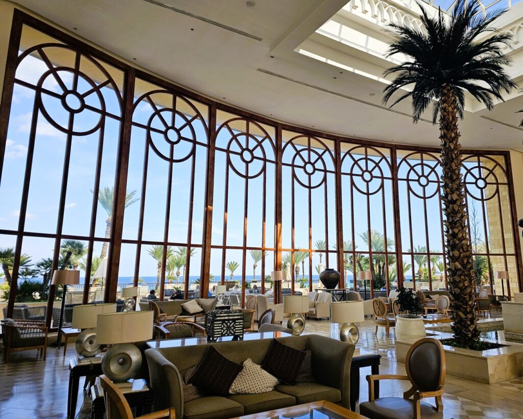 a glass fronted elegant foyer at Mövenpick Resort & Marine Spa 