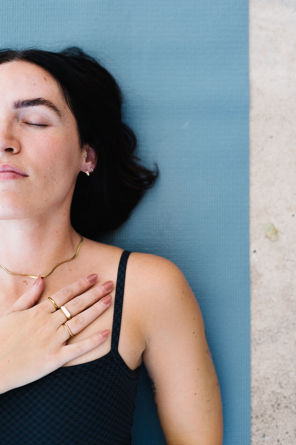 a woman laying on a yoga mat looking peaceful 