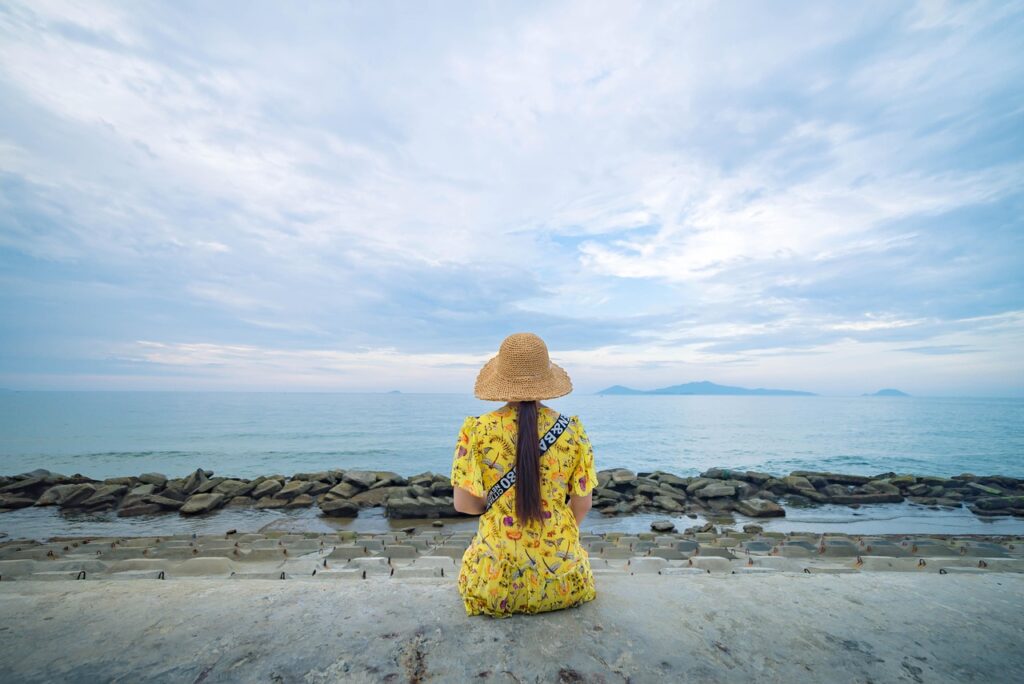 a woman sat alone overlooking the ocean 