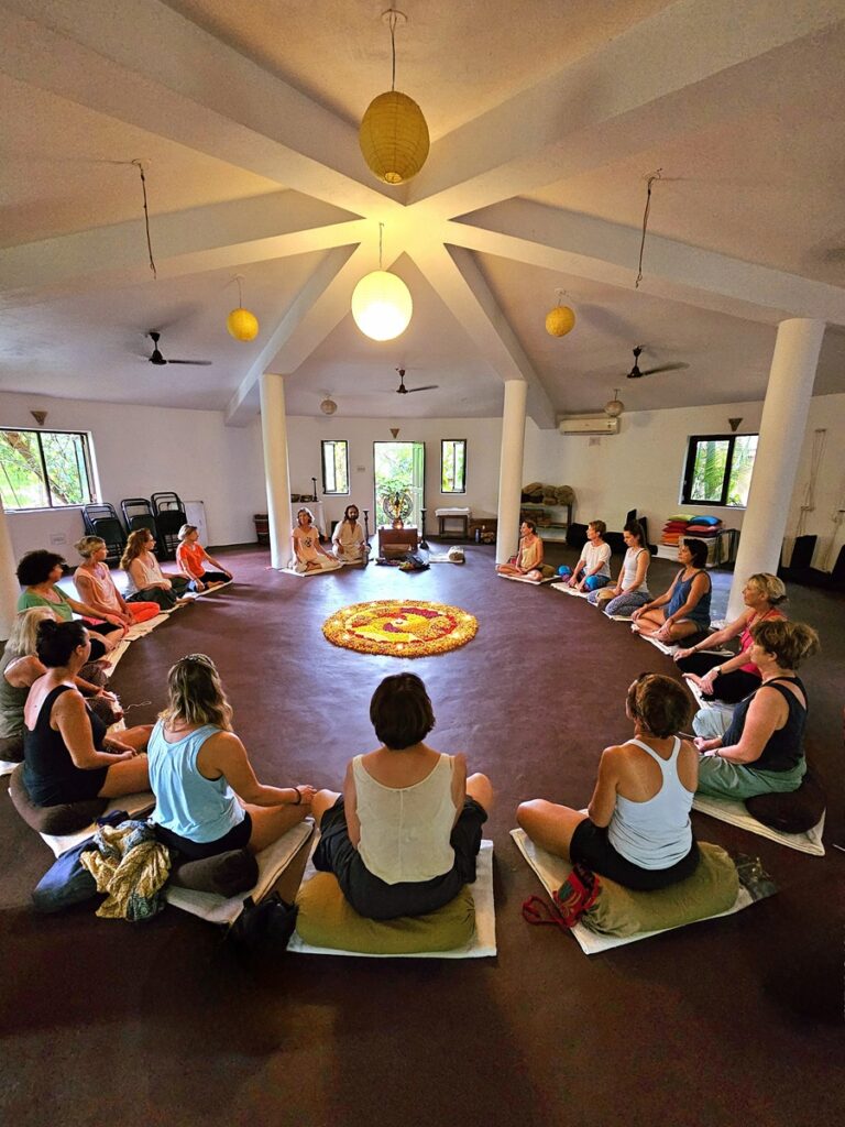 shows a group of people sitting in a circle at Ashiyana Yoga Retreat, Goa, India 