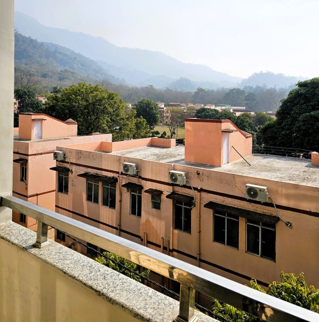 A balcony with a view over the hills and Parmarth Niketan Ashram