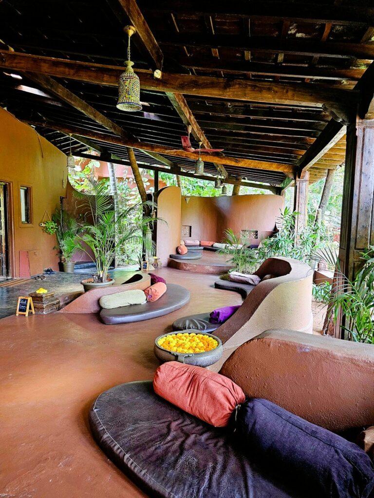 shows curvy lines, padded seating areas and bolsters at Ashiyana Yoga Retreat in Goa, India 