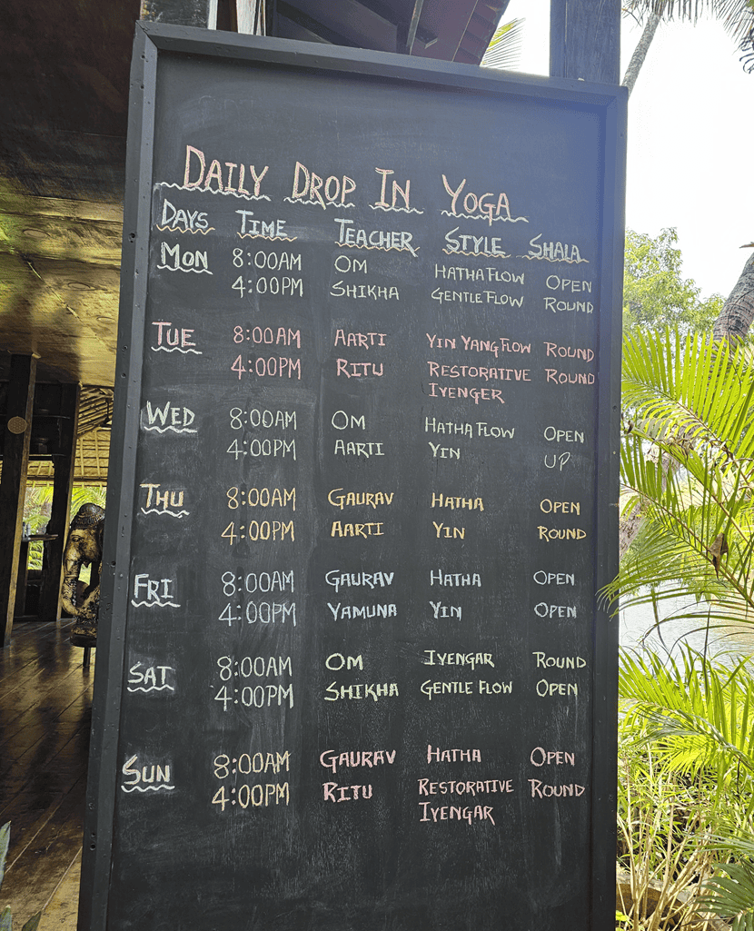 a blackboard showing the daily yoga at Ashiyana Yoga Retreat in Goa, India 