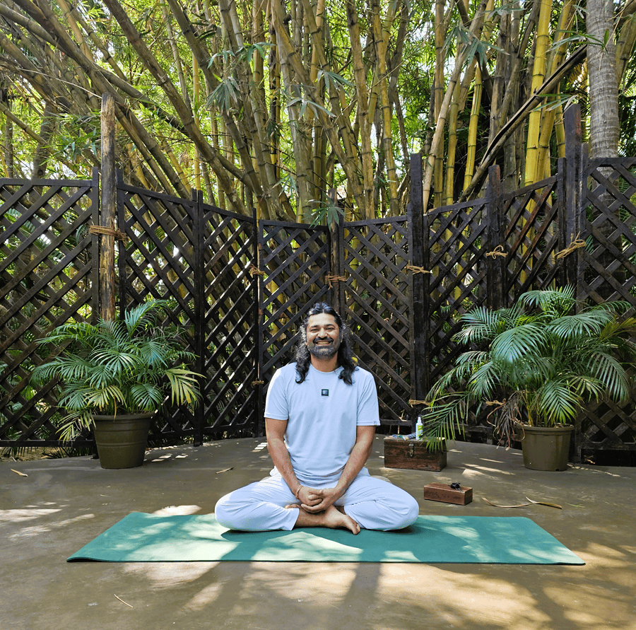 a yoga teacher sat on a mat at Ashiyana Yoga Retreat in Goa, India 