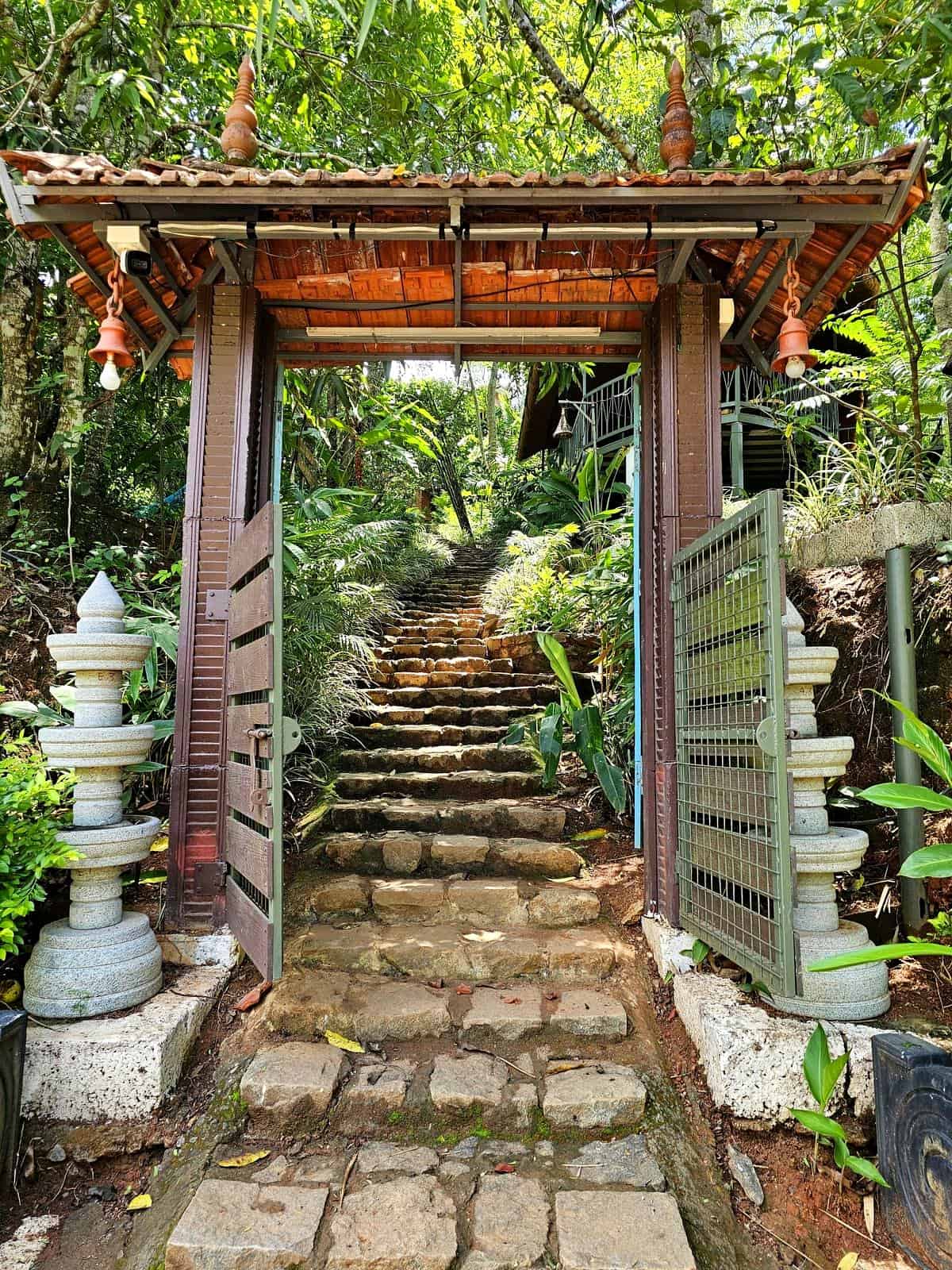 The beautifully carved wooden entrance to Tulsi Village Retreat in Munnar.