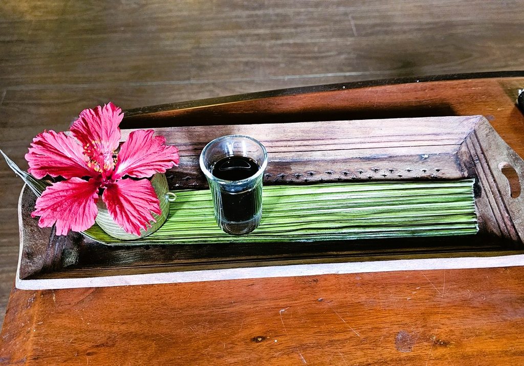 Gooseberry Juice on a tray with a pink flower at Blackberry Hills in Munnar
