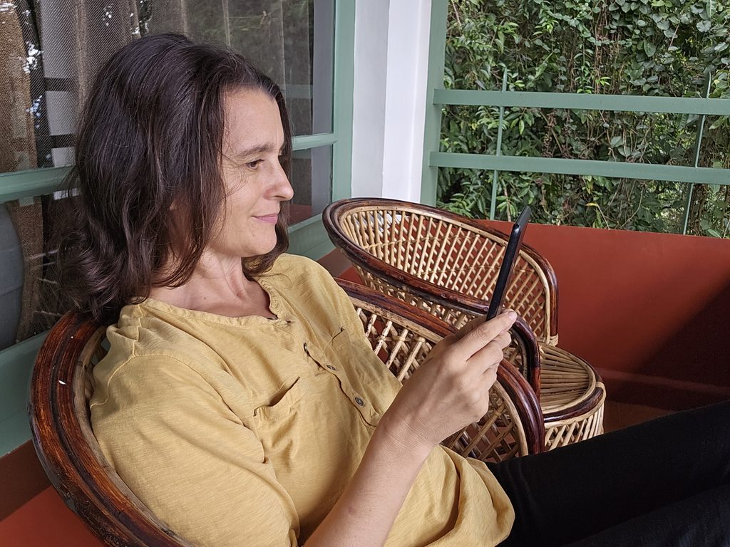 Myself reading a kindle on the balcony Blackberry Hills Hotel in Munnar