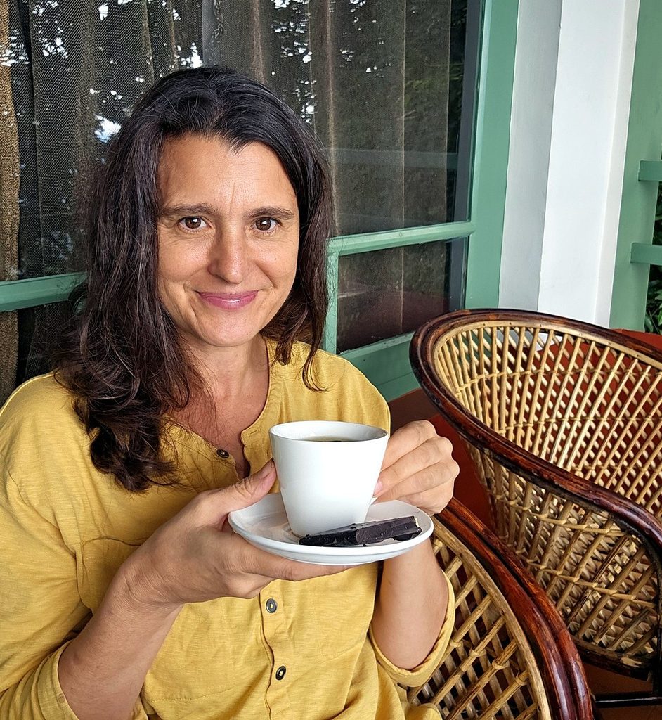 Jenny with a cup of tea and chocolate smiling at Blackberry Hills in Munnar