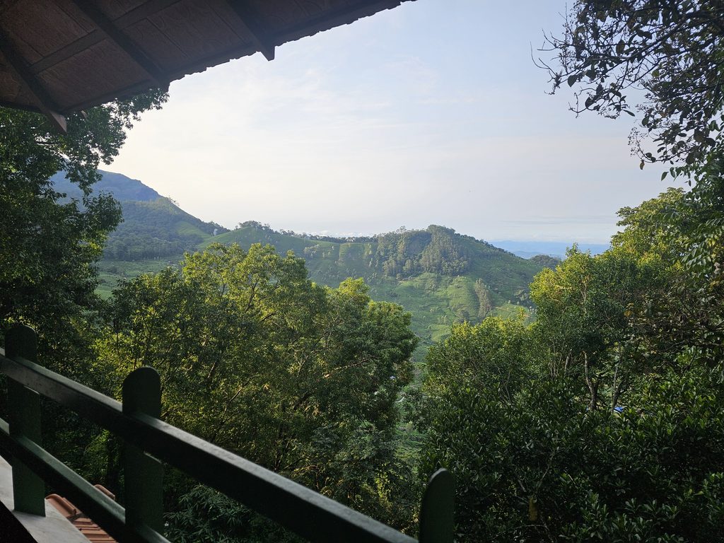 the view from the balcony at Blackberry Hills Hotel in Munnar showing green hills in the distance