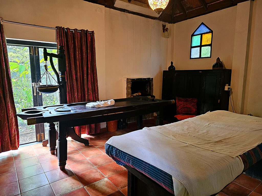Treatment rooms with a shirodhare table and massage couch at Amritara Shalimar Spice Garden Resort & Spa
