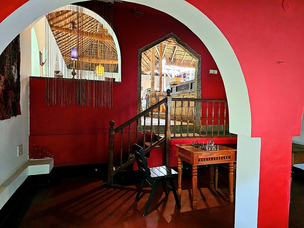 a red room with a chess table in the background at Amritara Shalimar Spice Garden Resort & Spa