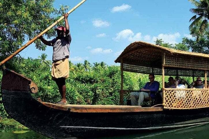 traditional eco boat showing a man punting with some people sat in the boat.