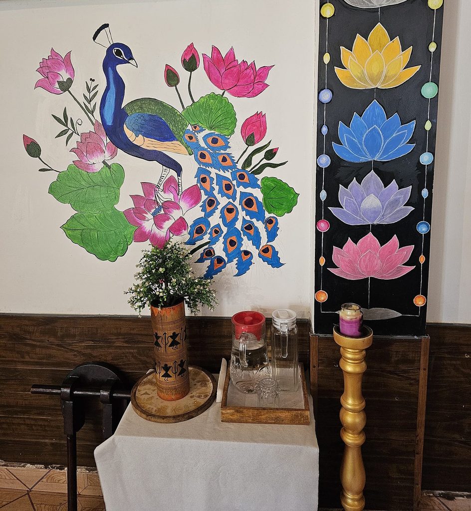 colourful image of a peacock and lotus flowers with candles at Veda5 Goa 