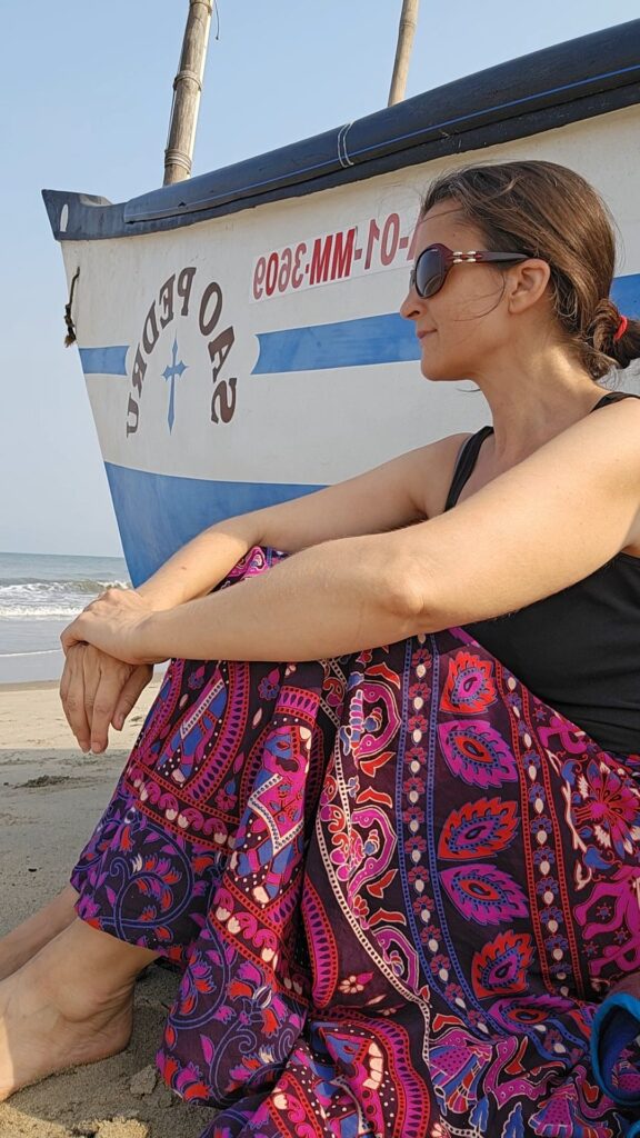 myself sitting next to a boat on the beach looking into the distance