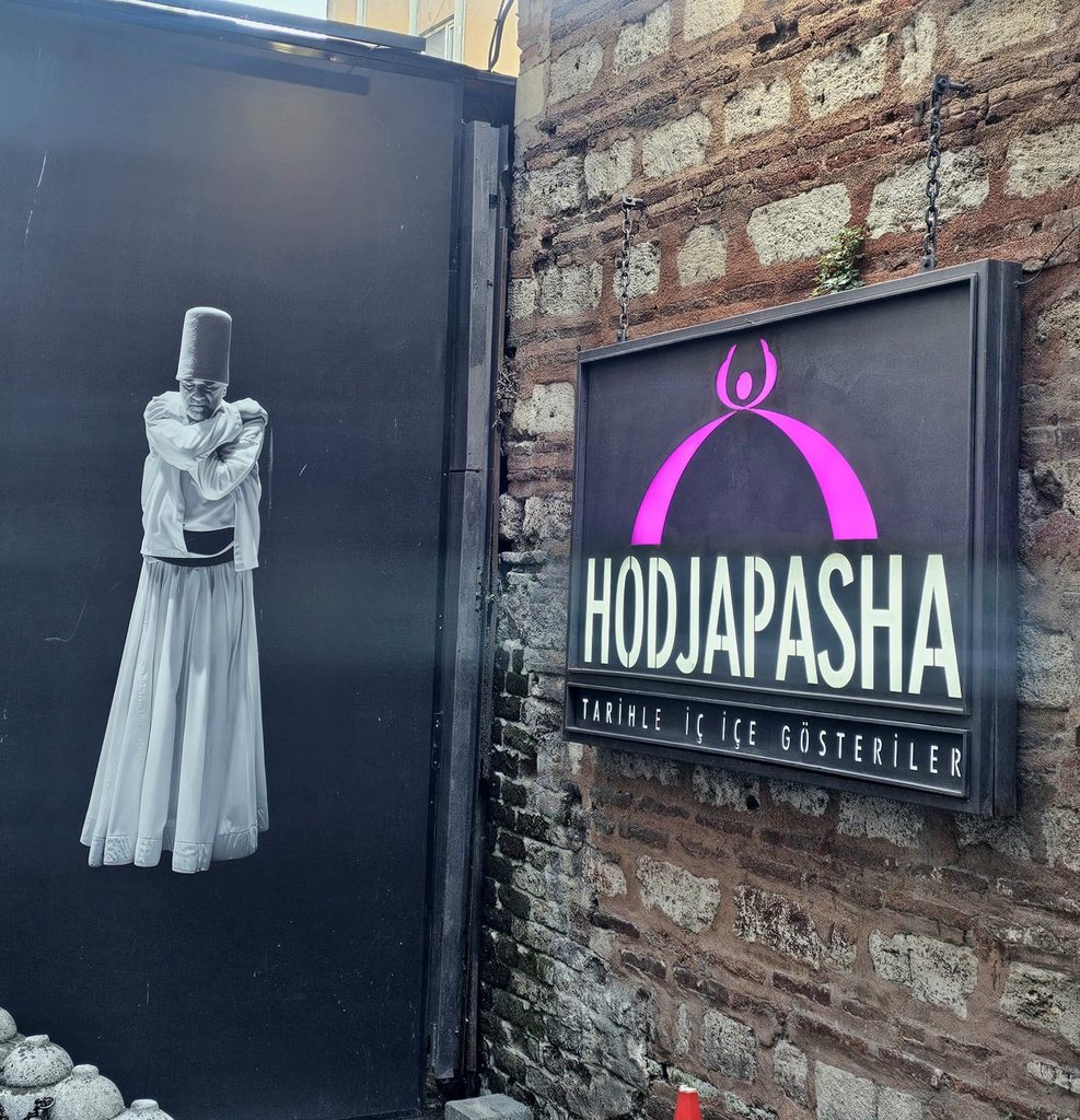 outside Hodjapasha Cultural Centre Istanbul, with an image of a dervish and the sign for the centre 