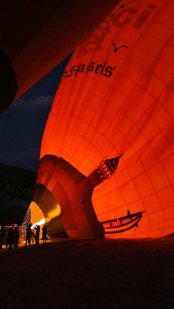 a bright red balloon being filled with air in Cappadocia