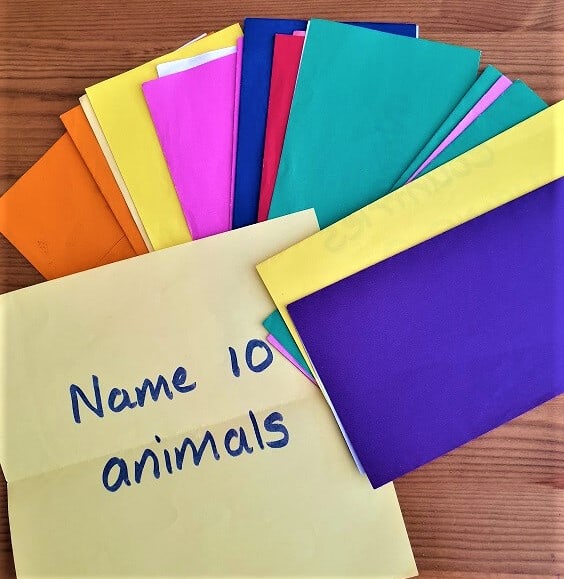 a selection of coloured paper folded in half, one is opened showing ' name 10 animals' 