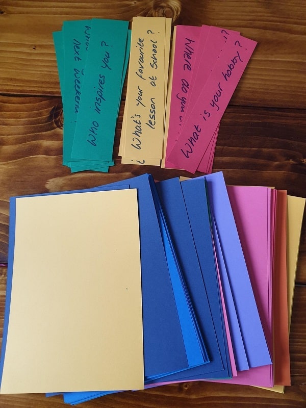 A selection of coloured paper and a set of questions on red, yellow green  paper