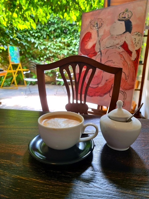 A coffee in front of a painting of Queen Victoria at Atelier 