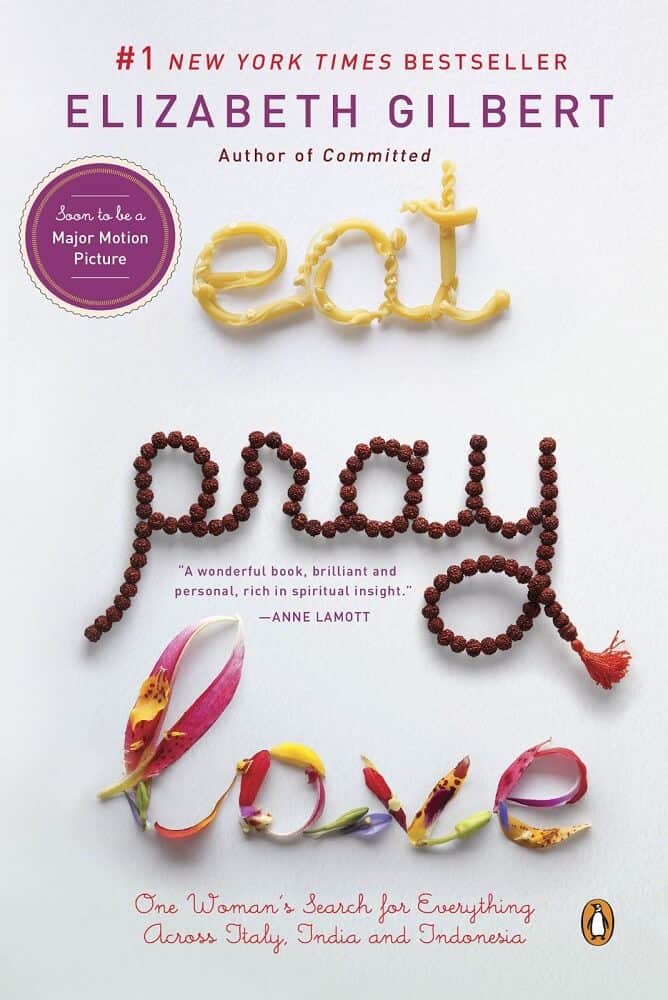 Image of book Eat Pray Love with writing in pasta for eat, prayer beads for pray and flowers for love